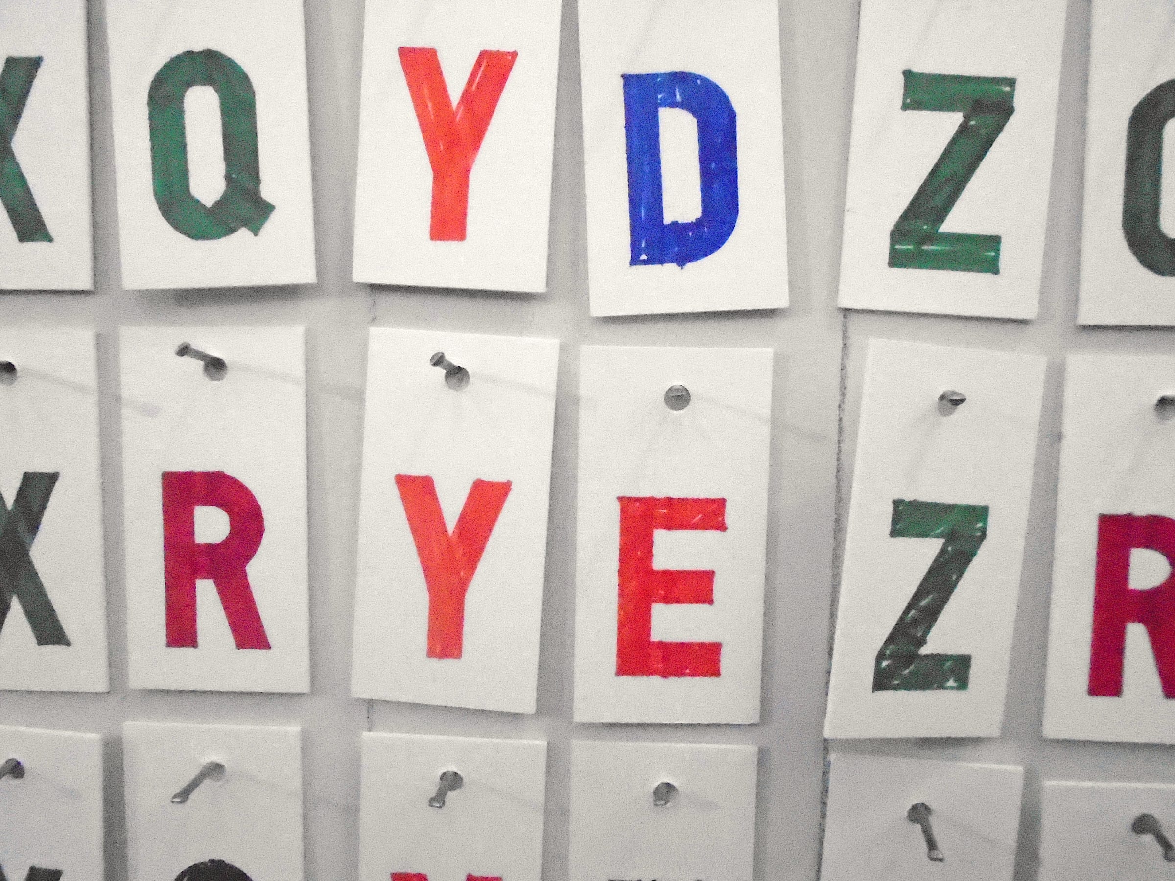cutouts of colorful letters hung on wall