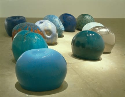 Several round sculptures that resemble colorful marbles on the floor.