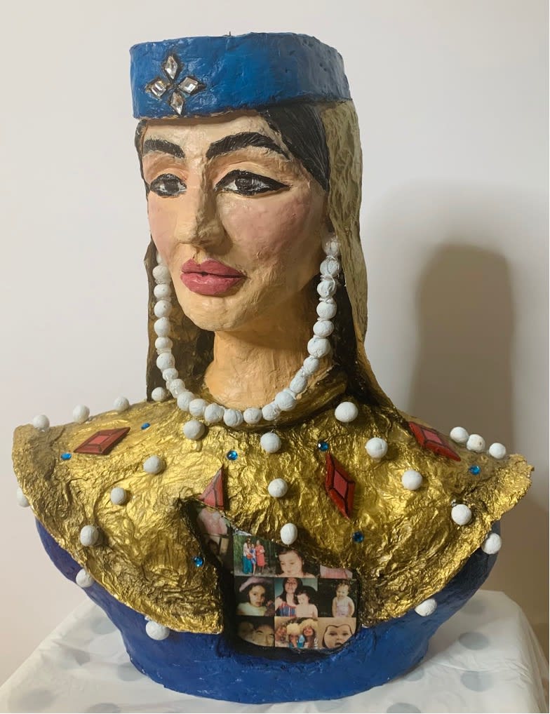 A painted carving of a woman's bust in blue and gold