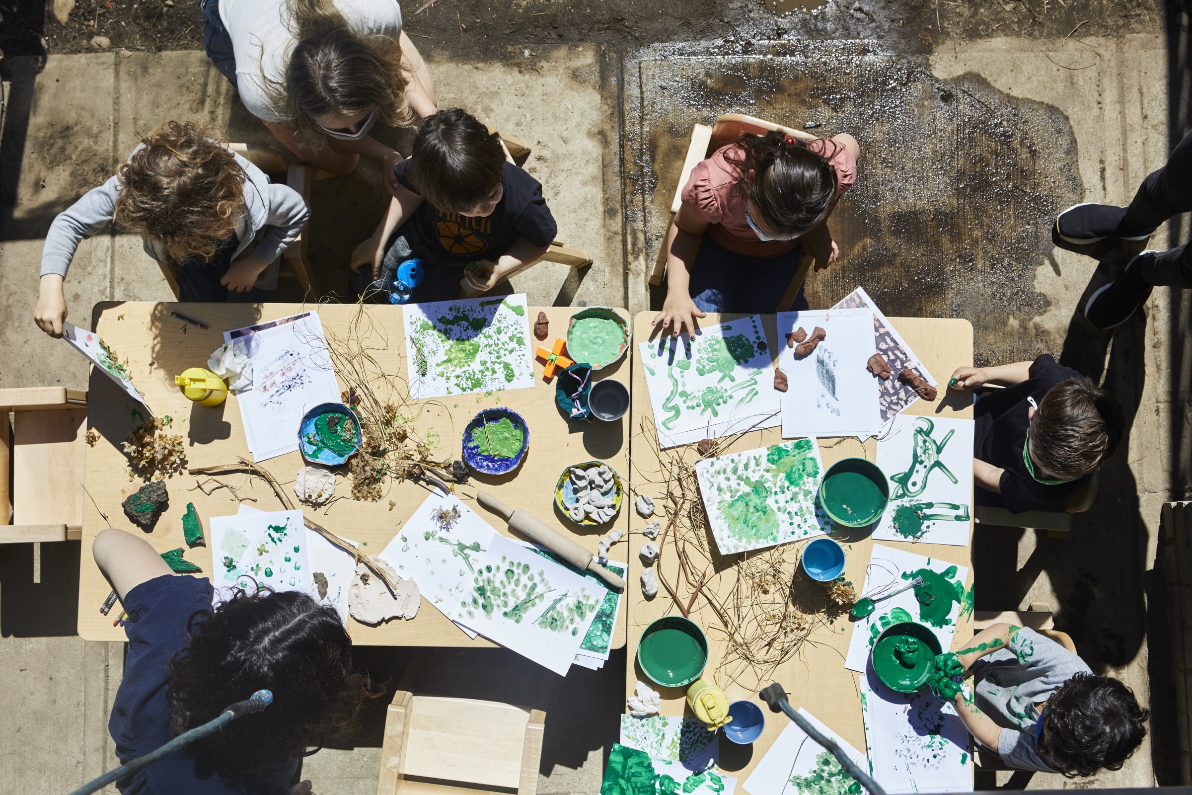 Ariel view of children making handprints with green paint