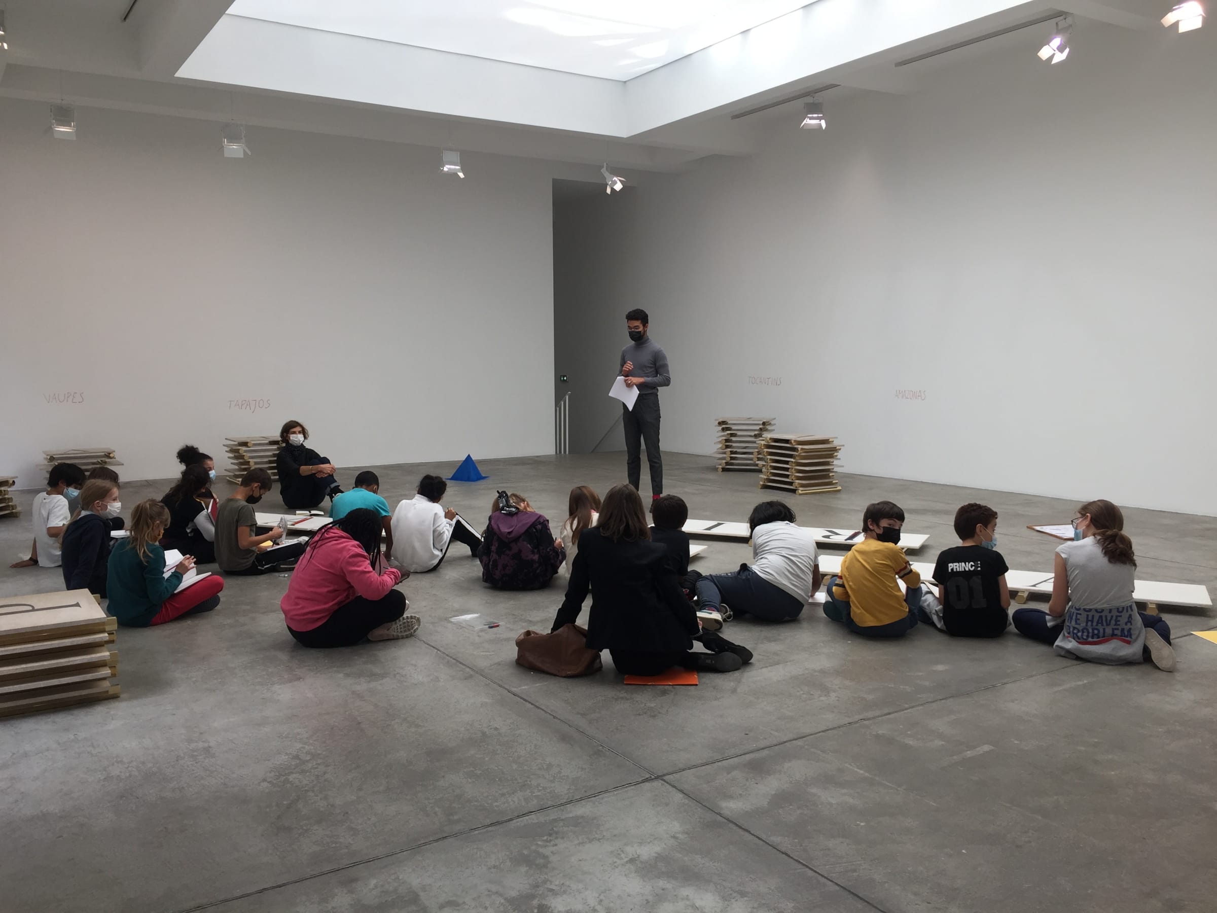 Kids on the floor of Marian Goodman Gallery in Paris  listening to a staff member talk about lothar baumgarten