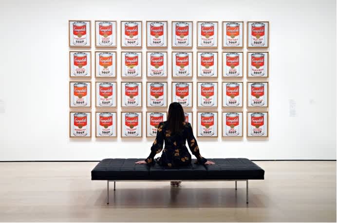 A woman views Andy Warhol’s Campbell’s Soup Cans at a museum in New York, reflecting on the series that helped make Andy Warhol art among the most expensive in the world.