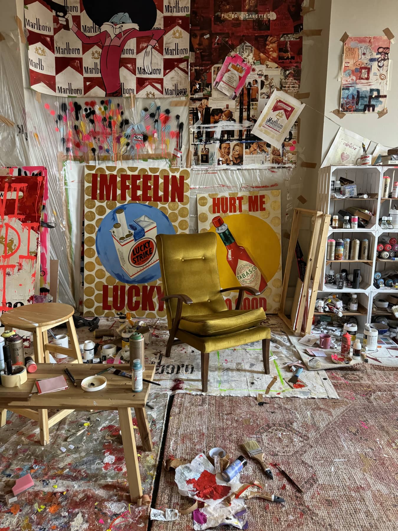 Charlotte Rose's art studio featuring her bold pop-art works, paint-splattered floors, and a retro yellow armchair — a vivid expression of contemporary rebellion and creative chaos.