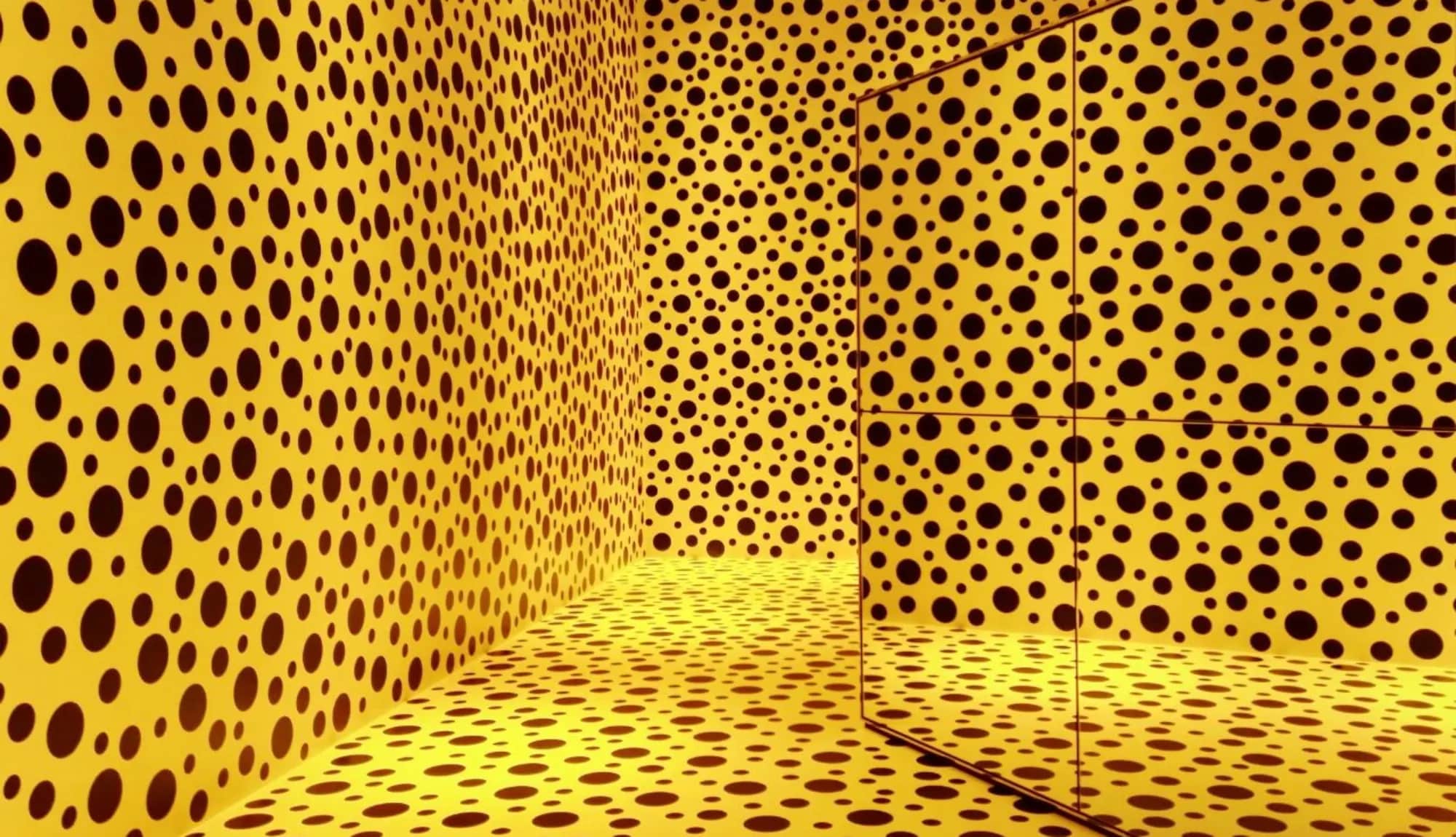 Immersive yellow room filled with black polka dots, a signature motif of Yayoi Kusama installations, often featured in major exhibitions and linked to record-breaking Kusama auction sales.