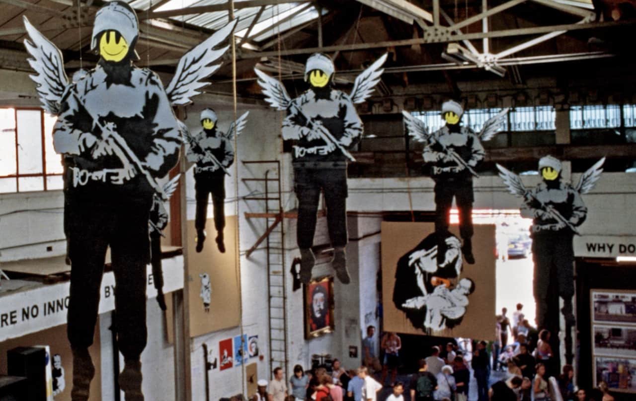 An installation view of Banksy’s 2003 Turf War show is a classic example of Contemporary political artists using their art for political change.