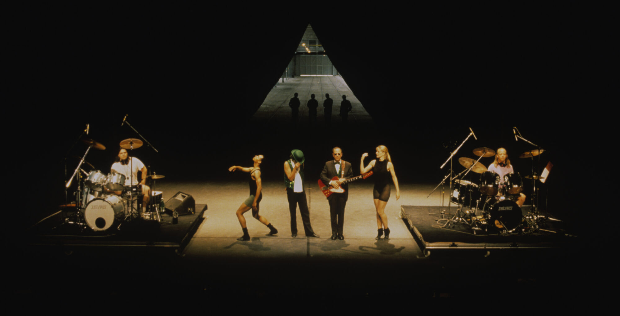 Mike Kelley, Anita Pace, Stephen Prina. Beat of the Traps. 1992. Performed in Expanded Art, Wiener Festwochen, The Remise, Vienna, Austria, 1992. Performers (from left): Jonathan “Butch” Norton, Carl Burkley, Alan Abelew, Stephen Prina, Anita Pace, M.B. Gordy. Ph: Karl Krauss. © Mike Kelley Foundation for the Arts. All Rights Reserved/VAGA at ARS, NY., Anita Pace, Stephen Prina