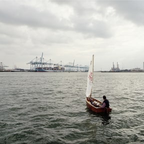 A Lambda photographic print on aluminium of a single boat and sailor in the Europahaven port of Rotterdam.