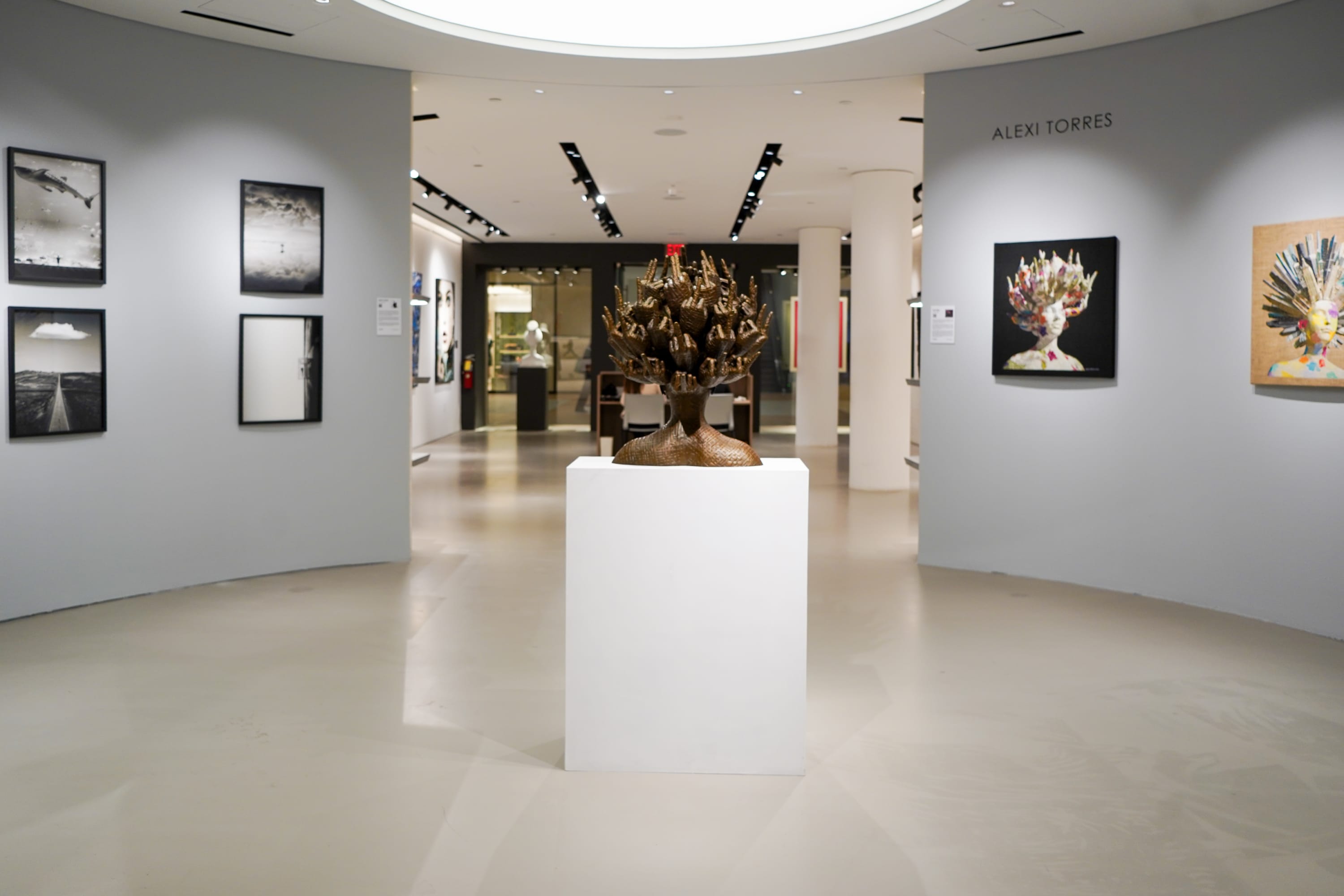 Modern luxury gallery interior, white wall aesthetics, polished concrete floors with art on display, available for purchase.