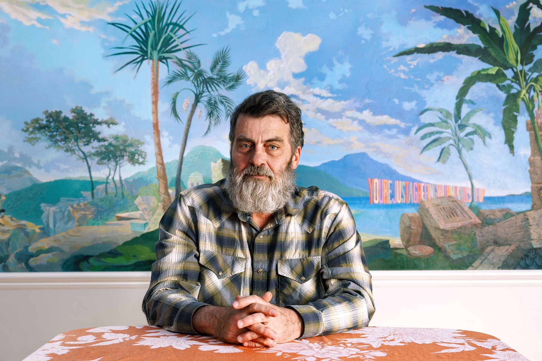 Portrait of Wayne White in his Los Angeles home with a mural painting he did in his dining room.