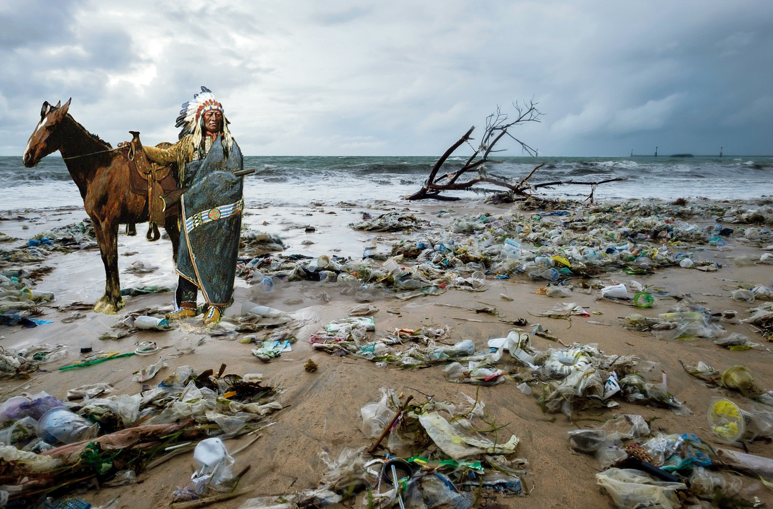 In this photograph, a beach at low tide fills the bottom two-thirds of the image. The beach is covered with huge piles of plastic waste, including bottles, cups, packaging, mixed with some small pieces of driftwood. In the distance, the tide is going out,