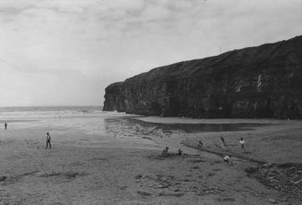 Jill Freedman, Untitled [Kids playing on beach, cliffs in background], 1985