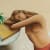 Jule Waibel painting of a bare chested woman resting her head on the side table with a book