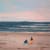 Jean Jullien minimal painting of two surfers looking towards the water. Pink sunset
