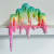 Drippy sculpture with a green, yellow,pink and purple gradient with shine by Dan Lam
