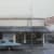 detail of Kim Cogan painting of pizzeria with blue car parked out front