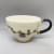 Fliff Carr delicate cream teacup with black handle and a cornflower design