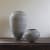 Two black and white patterned ceramic vessels by Ant & Di Edmonds Tydd Pottery sit on a dark wood table at Sarah Wiseman Gallery