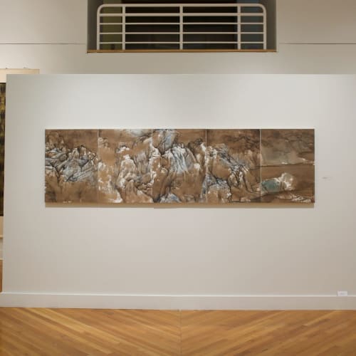 A five-screen landscape painting with brown tones and green-blue mountains hanging in the museum display