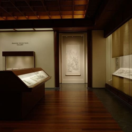 The museum's exhibition hall, with a long display case in the middle and transparent display tables on either side that also hold scrolls