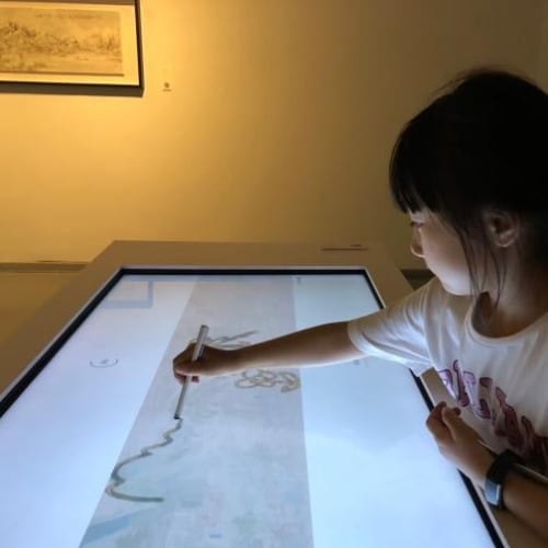 A child drawing on a touch screen