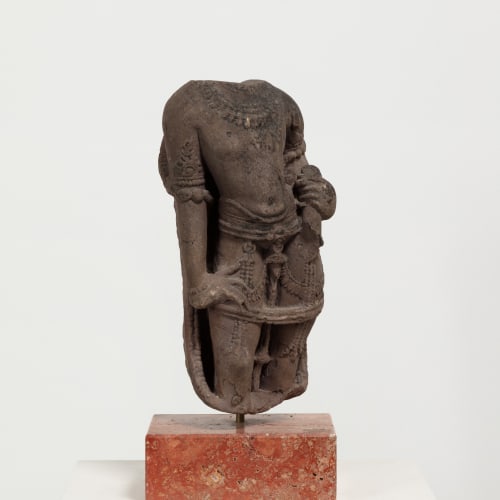 <p><span><span>A stone torso of a male deity, India, 12th century or later, 18 inches (45.8cm) including stand.</span></span></p>