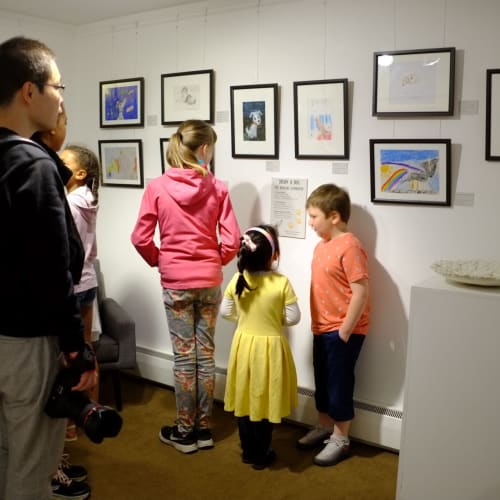 Some children and their families are looking at the art on display at Sarah Wiseman Gallery