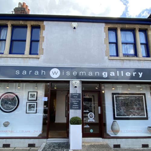 A view of Sarah Wiseman Gallery from outside. It's sunny weather and the windows display new works by Ade Adesina