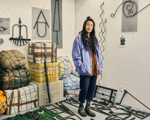Ms. Lee’s studio in Gowanus, Brooklyn, with welded symbols, and burlap “luggage.” Credit...Christopher Gregory for The New York Times