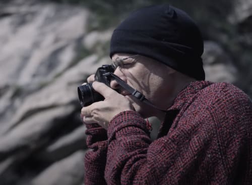 Portrait of Michael Cherney holding his camera