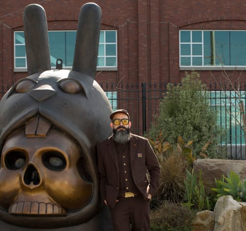 Portrait of the artist Jeremy Fish in front of his Bronze Bunny statue.