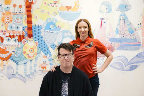 husband and wife artist duo Kefe standing in front of their mural