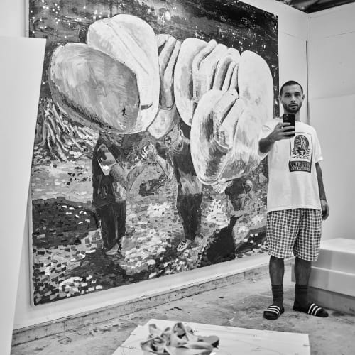 American artist Ken Taylor Reynaga in his studio in front of his artwork