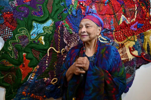Artist Joyce J. Scott at the Baltimore Museum of Art with “Spring to Fall (Four Seasons),” 1991. The museum will open a retrospective of Scott’s 50-year career on Sunday. (Kim Hairston/Staff)