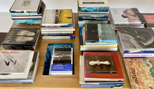 A table with multiple stacks of books for sale.