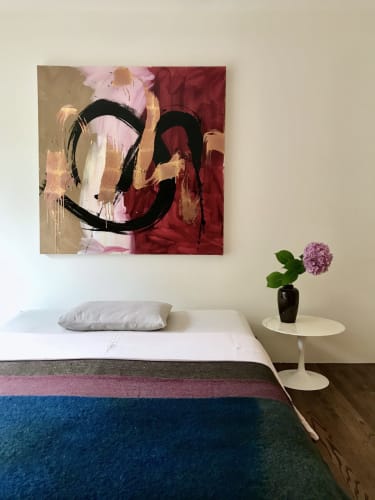 Bedroom with large square painting by Max Gimblett. The painting depicts swaths of red, pink, and ochre with large gestural black and gilded brushstrokes over top.