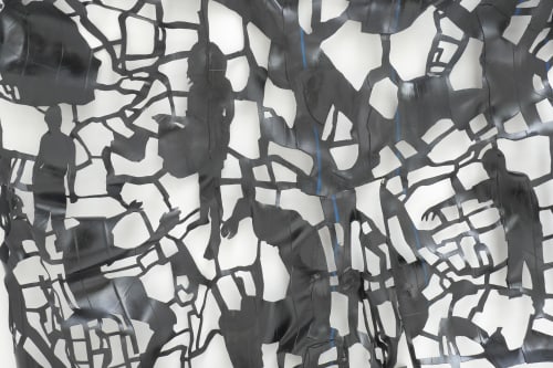 incisions in a black rubber car tire inner tube creating outlines of figures within a network of irregular grid forms