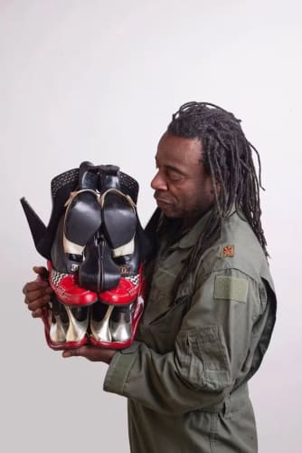 Artist Willie Cole (SVA BFA 1976 Media Arts) with one of his sculptures made of women’s shoes.