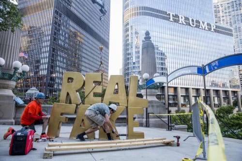 From left, Terry Karpowicz and Oakley Gregory install a sculpture by Scott Reeder titled "Real Fake" near the intersection of North Wabash Avenue and East Upper Wacker Drive on June 26, 2017, in Chicago. (Armando L. Sanchez / Chicago Tribune)
