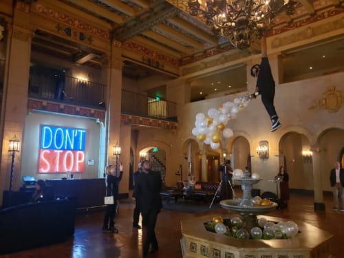 A neon sign by Deborah Kass and a chandelier/fountain sculpture of a dangling man by Luis Flores are in the Hollywood Roosevelt lobby.(Christopher Knight/Los Angeles Times )