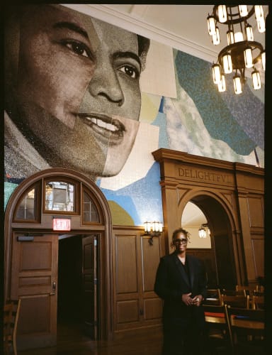 Mickalene Thomas with her mural depicting Pauli Murray, a champion of civil and women's rights, in the dining hall of the resident college at Yale named for Murray. Image courtesy of Luisa Opalesky.