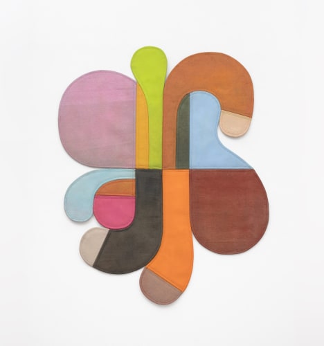 Flat shallow sculpture of curvilinear shapes on a white wall. 