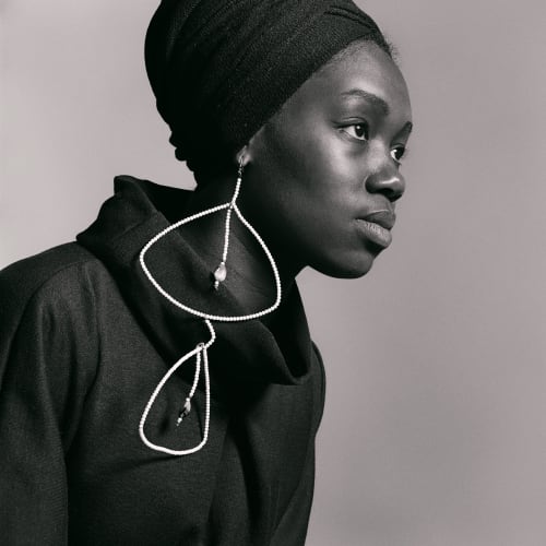 Kwame Brathwaite, Untitled (Nomsa Brath with earrings designed by Carolee Prince), (1964). Archival pigment print, 15 x 15 inches.