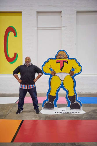 Portrait of Trenton Doyle Hancock standing in the same position as his Torpedoboy character