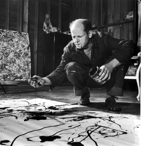 PAINTER JACKSON POLLOCK, CIGARETTE IN MOUTH, DROPPING PAINT ONTO CANVAS. PHOTOGRAPH COURTESY OF MARTHA HOLMES/THE LIFE PICTURE COLLECTION/GETTY.