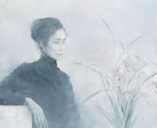 A young lady in black cloth sits on a white chair looking towards the right and viewing the flowers