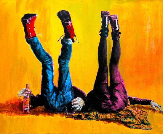 Couple lying with their backs on the floor and legs in the air holding a bottle on yellow background