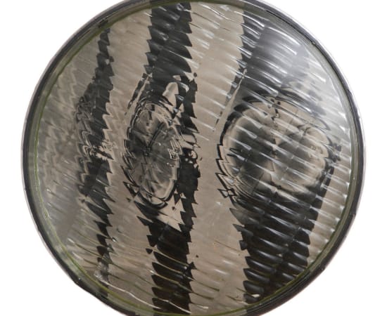 œuvre unique de l'artiste Thomas Mailender rerpésentant une photographie vintage de magazine montée sous un phare de voiture