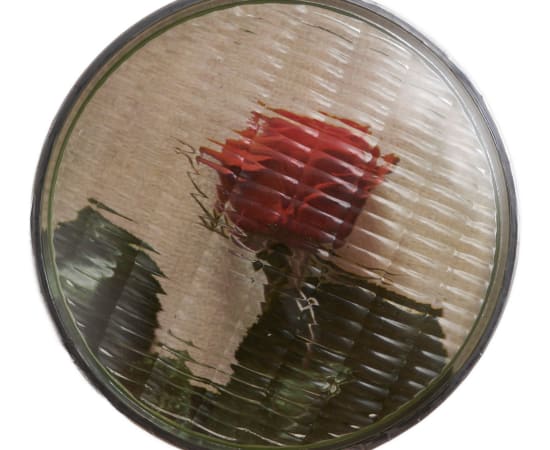 œuvre unique de l'artiste Thomas Mailender rerpésentant une photographie vintage de magazine montée sous un phare de voiture