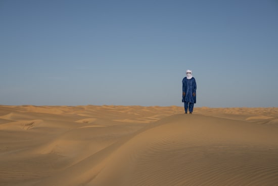 photograph of a man in the Saharan desert by Raphael Avigdor represented by Rebecca Hossack gallery