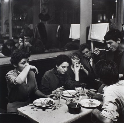 Dinner in a cafe. Girl wipes her nose with her wrist. Paris, ca. 1952